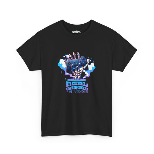 Black T-shirt featuring a colorful graphic of a skeletal hand holding a game controller with clouds of smoke, above the text 'REAL GAMERS TAKE TURNS DYING' | Satire Clothes