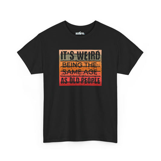 Black t-shirt with text 'IT'S WEIRD BEING THE SAME AGE AS OLD PEOPLE' in a retro gradient design | Satire Clothes