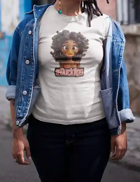 Woman wearing a white t-shirt with a humorous cartoon duck with human-like curly hair and hoop earrings, text reads #Ducklips in pink, layered under a denim jacket | Satire Clothes