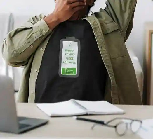 Man wearing a black t-shirt with a graphic of a battery icon displaying 'Energy Saving Mode Activated' text and a sleeping person icon | Satire Clothes