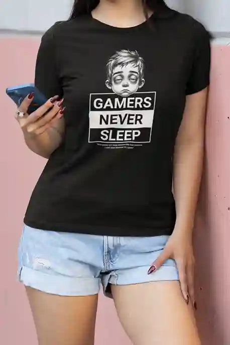 Woman wearing a black T-Shirt with an illustration of a tired looking person with the text "Gamers Never Sleep" in bold white and black blocks underneath. | Satire Clothes