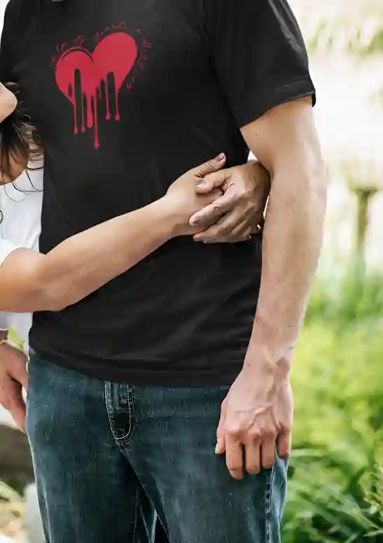 A man wearing a black t-shirt with a red melting heart design and the text "Help, My Heart is Melting" written in a playful font around the heart | Satire Clothes