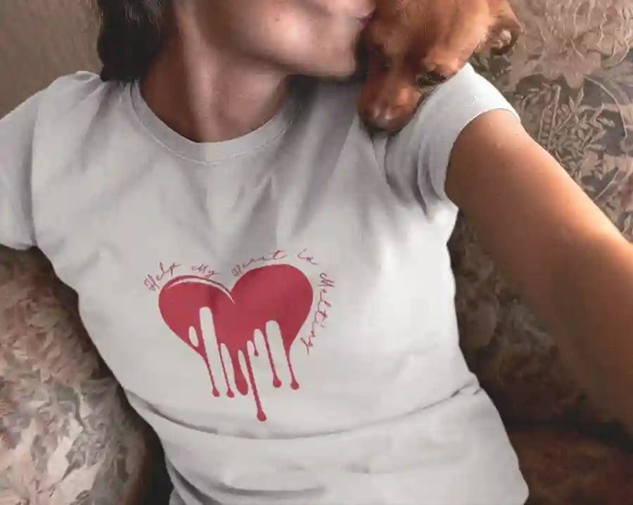 A woman wearing a white t-shirt with a red melting heart design and the text "Help, My Heart is Melting" written in a playful font around the heart | Satire Clothes