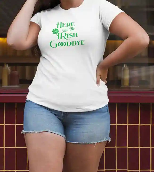 A woman wearing  a white t-shirt with the text 'Here For The IRISH Goodbye' in green, featuring a green shamrock design in place of the 'I' in 'IRISH' | Satire Clothes