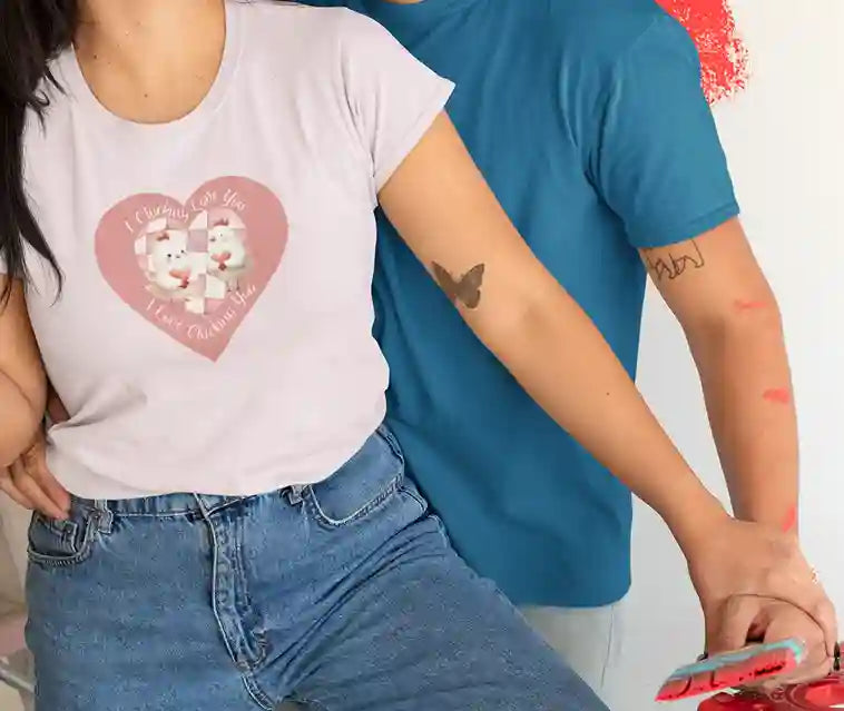 A woman wearing a light pink t-shirt featuring a pink heart-shaped design with two cartoon chickens holding a heart. The text on the shirt reads "I Clucking Love You .. I Love Clucking You" in a playful font. | Satire Clothes