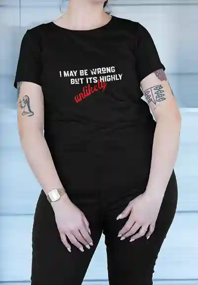 Woman wearing a black t-shirt with humorous text 'I MAY BE WRONG BUT IT'S HIGHLY unlikely' | Satire Clothes