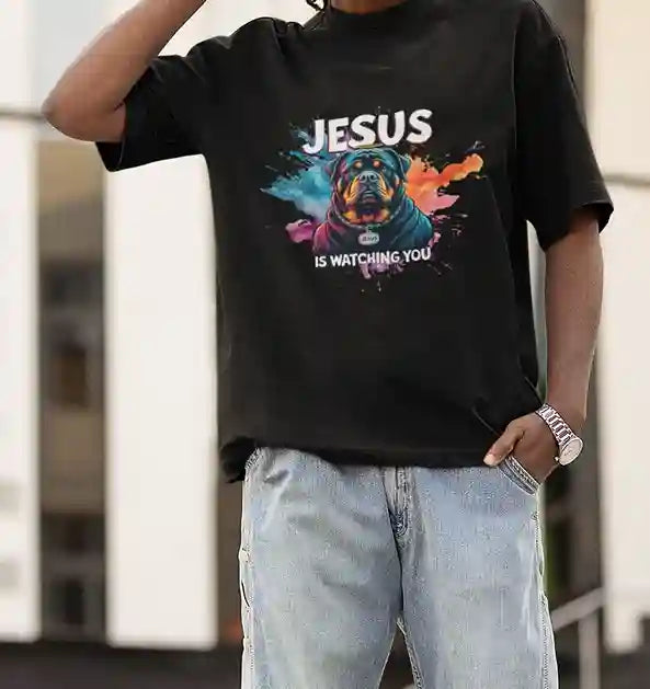 Man wearing black T-shirt with a colorful Rottweiler graphic and 'JESUS IS WATCHING YOU' text | Satire Clothes