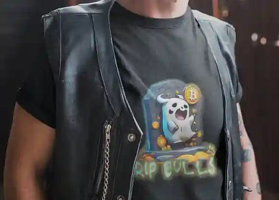 A man wearing a black t-shirt with a cartoon ghost emerging from a tombstone, holding a Bitcoin symbol. The ghost is surrounded by small Bitcoin icons and the text "RIP BULLS" is glowing below in green and blue | Satire Clothes.