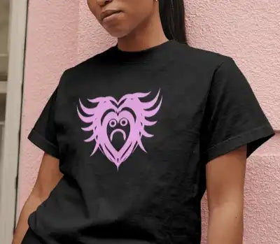 A woman wearing a black t-shirt with a pink design featuring a sad, crying heart with wing-like extensions. | Satire Clothes