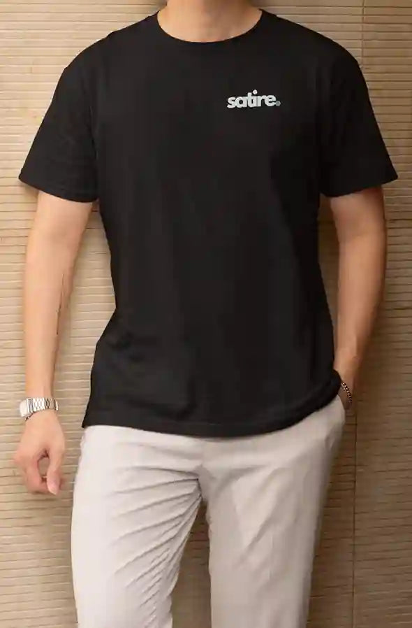 Man wearing a black t-shirt with the 'Satire.' logo in white and blue text on the left chest area. | Satire Clothes