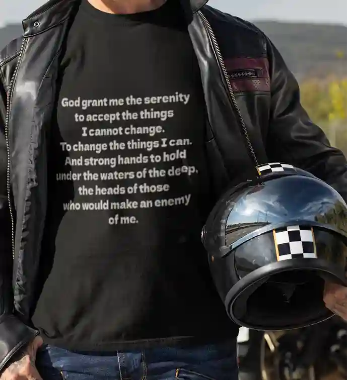 Man wearing a black t-shirt with white text that reads: "God grant me the serenity to accept the things I cannot change. To change the things I can. And strong hands to hold under the waters of the deep, the heads of those who would make an enemy of me." | Satire Clothes