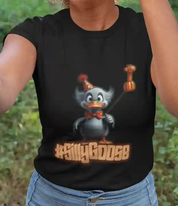 A woman wearing a black t-shirt featuring a cartoon goose wearing a party hat and holding a giraffe balloon, with the text "#SillyGoose" printed below the image | Satire Clothes