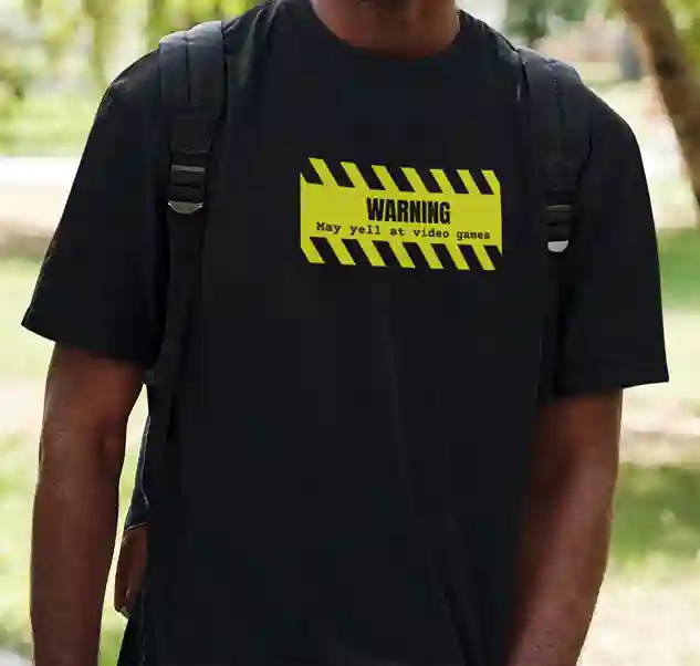 A man wearing a black t-shirt with a yellow and black striped warning sign graphic which says 'WARNING: May yell at video games' in bold black text | Satire Clothes