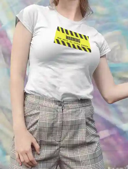 Woman wearing a white t-shirt with a yellow and black striped warning sign graphic which says 'WARNING: May yell at video games' in bold black text | Satire Clothes