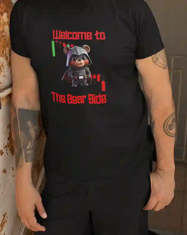 A man wearing a black T-Shirt with 'Welcome to The Bear Side' text in red, featuring a cute bear wearing a black helmet and uniform with a cape, amidst stock market graphs, symbolizing a humorous take on the bear market. | Satire Clothes